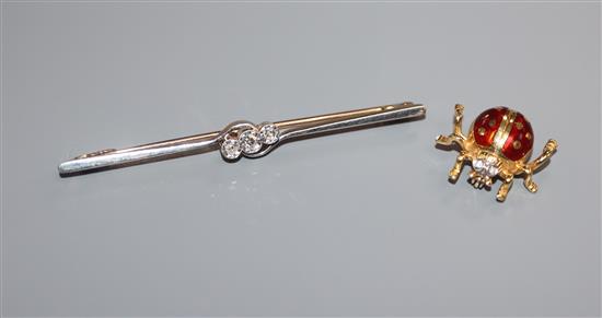 A 1920s 15ct, plat and three stone diamond bar brooch and an Italian 18k and enamel ladybird brooch.